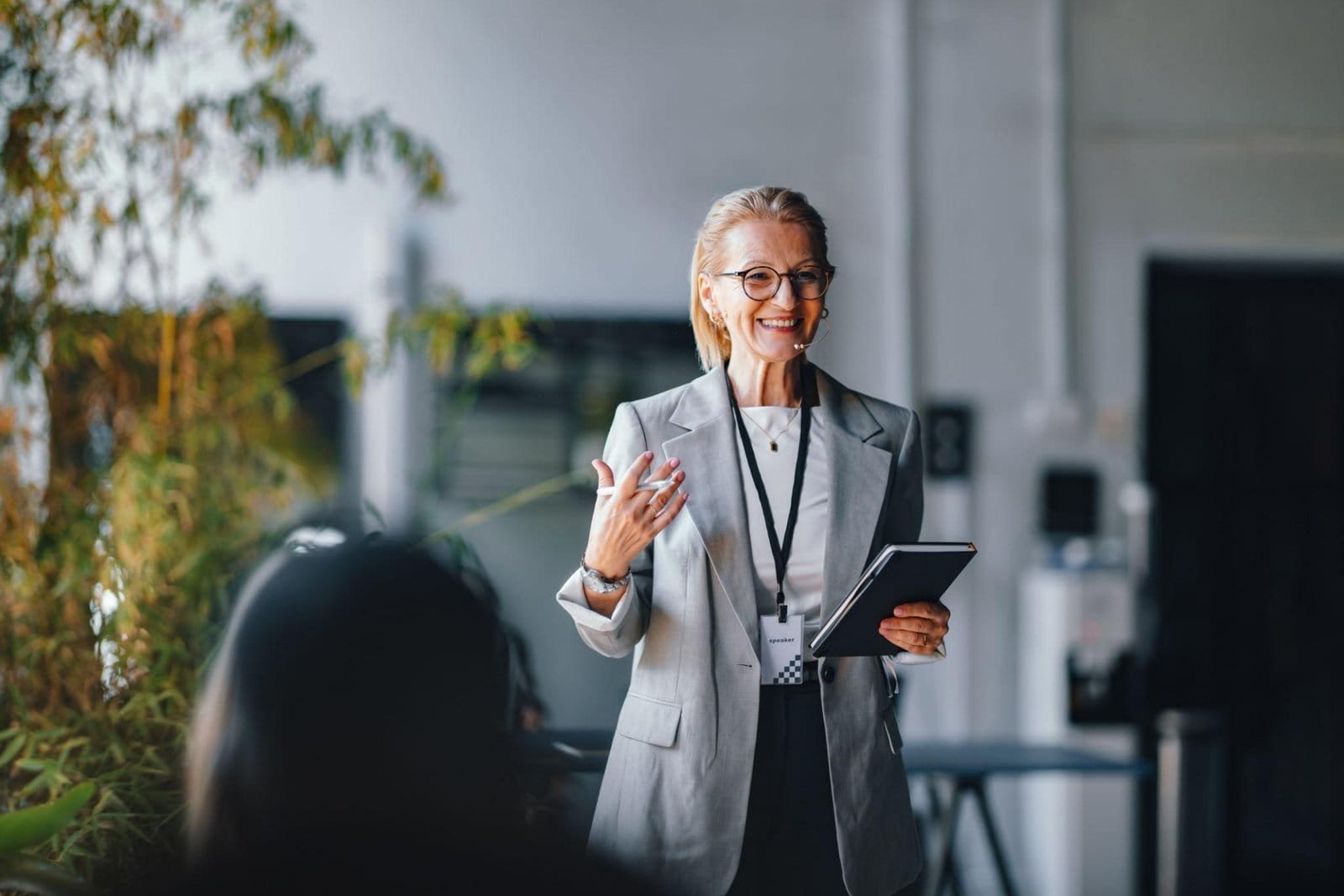 “Professional woman speaking at business presentation with tablet”